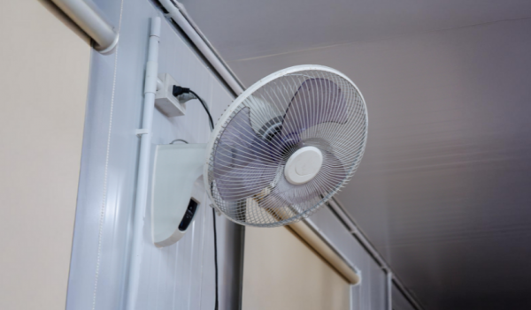 Ventilador de parede branco fixado em uma prede branca