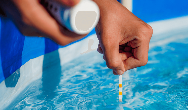 Profissional medindo o pH da água da piscina com uma tira 