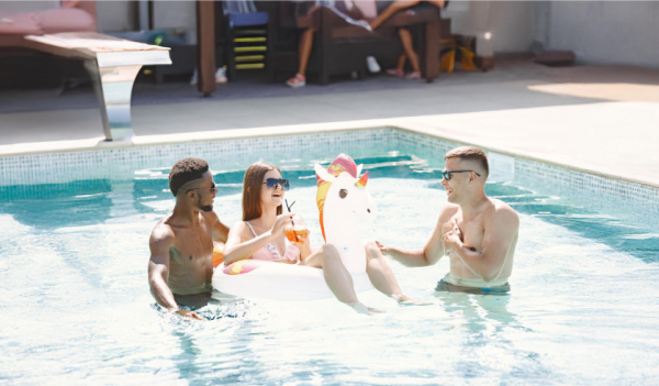 Dois homens e uma mulher se divertindo na piscina de um hotel durante as férias de verão